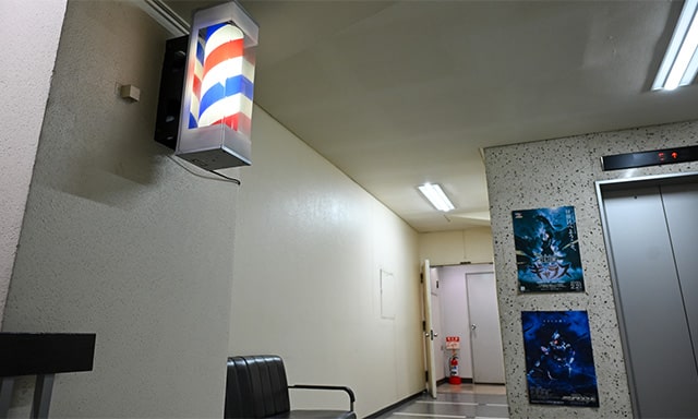 エレベーター脇にお馴染みの理容店のアレが。この奥に理容室がある。